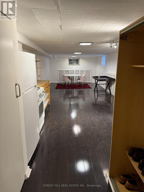 A kitchen with white appliances and a dining table with chairs.