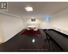 A spacious room with a white couch and a red rug.