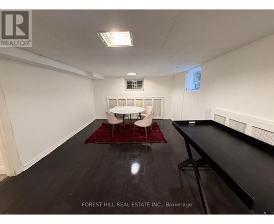 A spacious room with a white couch and a red rug.