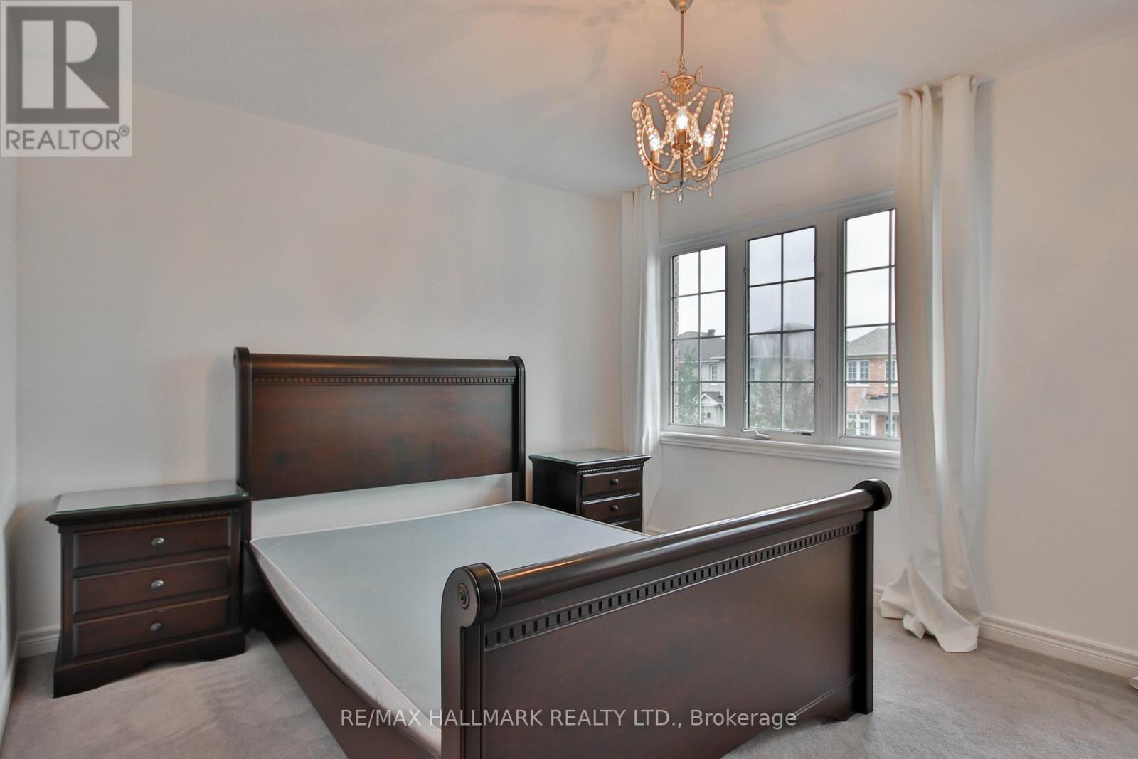 A bedroom with a large bed and a chandelier.