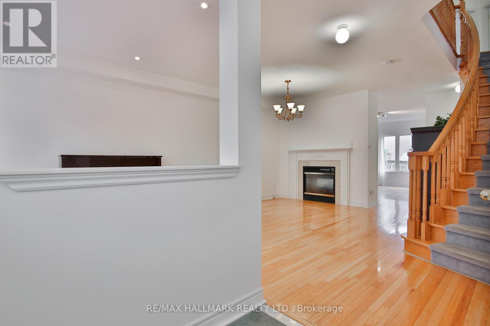 A living room with a fireplace and a staircase.