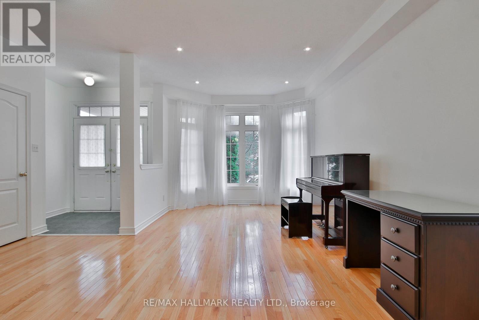A spacious room with wooden floors and white walls.