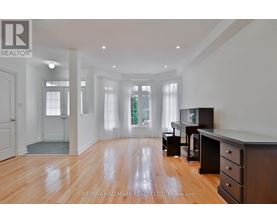 A spacious room with wooden floors and white walls.