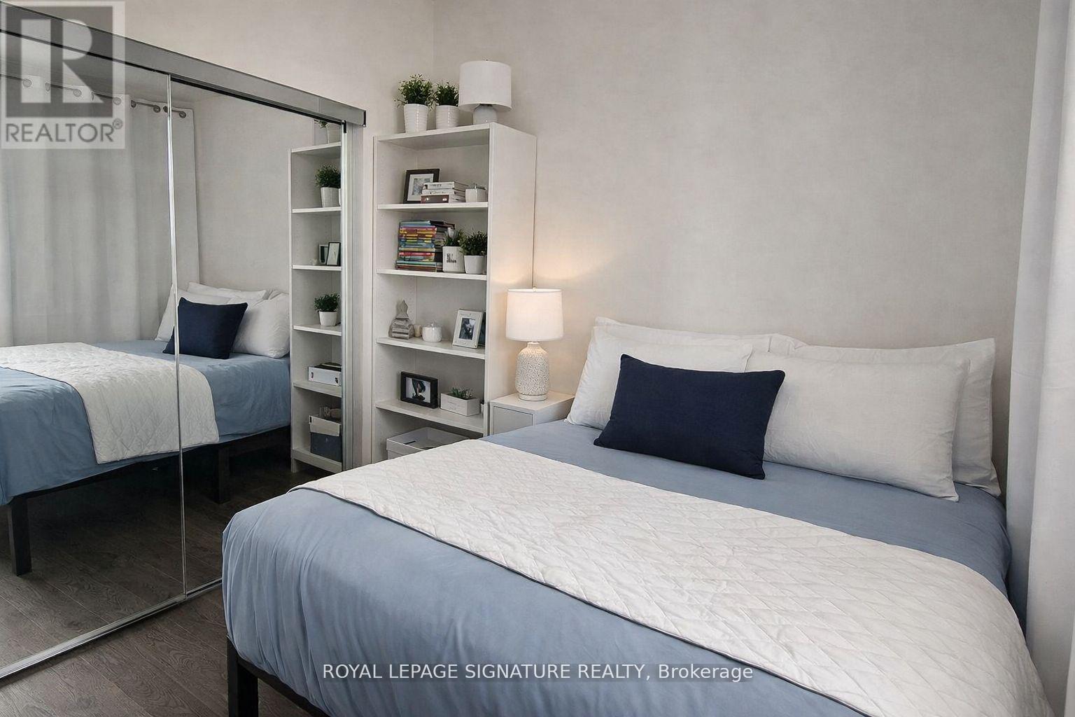 A bedroom with a bed, nightstand, and a shelf with decorative items.