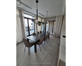 A dining room with a table and chairs.