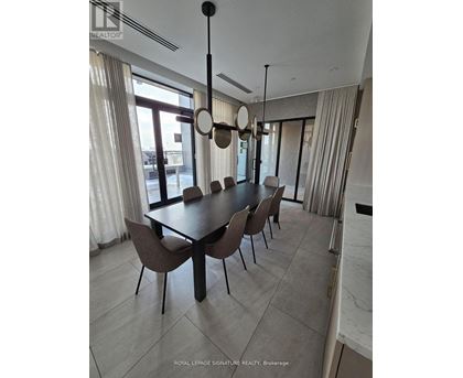 A dining room with a table and chairs.