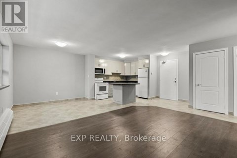 A realtor photo of an empty room with a kitchenette.