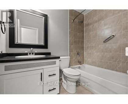 A bathroom with a toilet, sink, and bathtub.