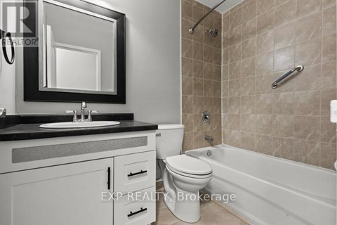 A bathroom with a toilet, sink, and bathtub.