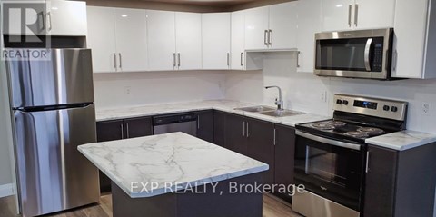 A kitchen with a marble countertop and stainless steel appliances.