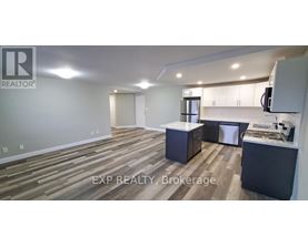 A realtor's office with wood flooring and a kitchenette.
