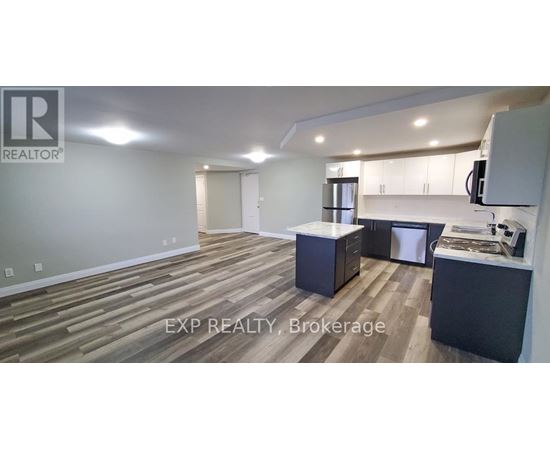 A realtor's office with wood flooring and a kitchenette.