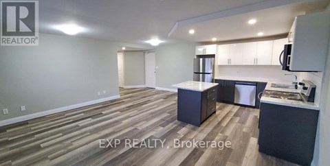 A realtor's office with wood flooring and a kitchenette.