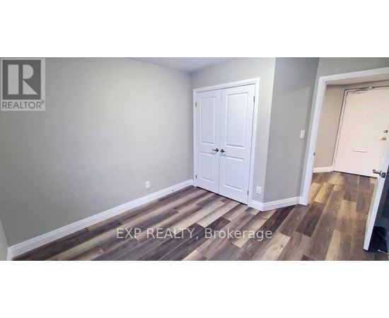 A room with a white door and a wooden floor.
