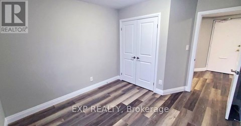 A room with a white door and a wooden floor.