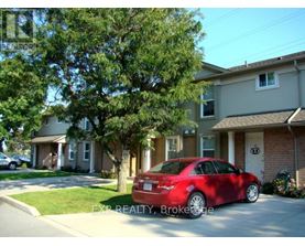 A red car is parked in front of a house.