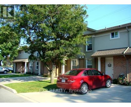 A red car is parked in front of a house.