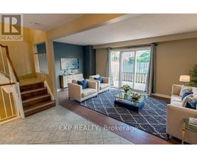 A living room with a staircase and a glass table.