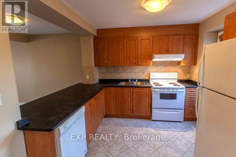 A kitchen with wooden cabinets and a white dishwasher.