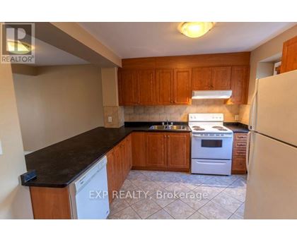 A kitchen with wooden cabinets and a white dishwasher.