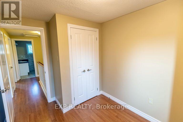 A hallway with a white door and EXP Realty, Brokerage written on the wall.