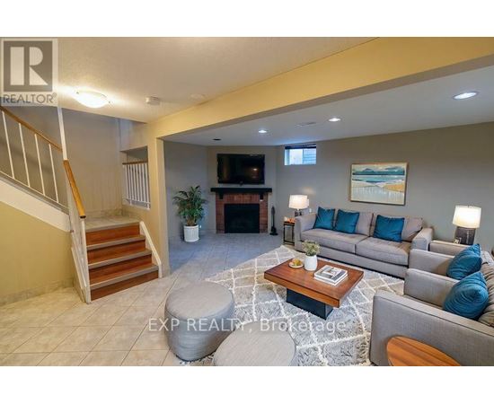 A living room with a couch, coffee table, and staircase.
