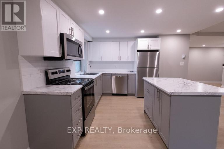 A modern kitchen with white cabinets and stainless steel appliances.
