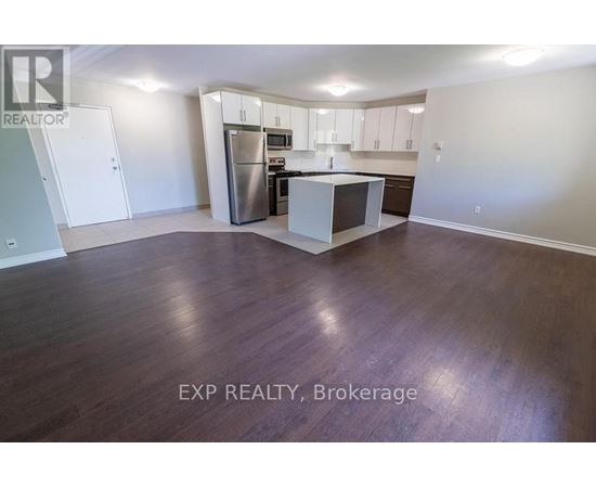 A kitchen with white cabinets and a stainless steel refrigerator.