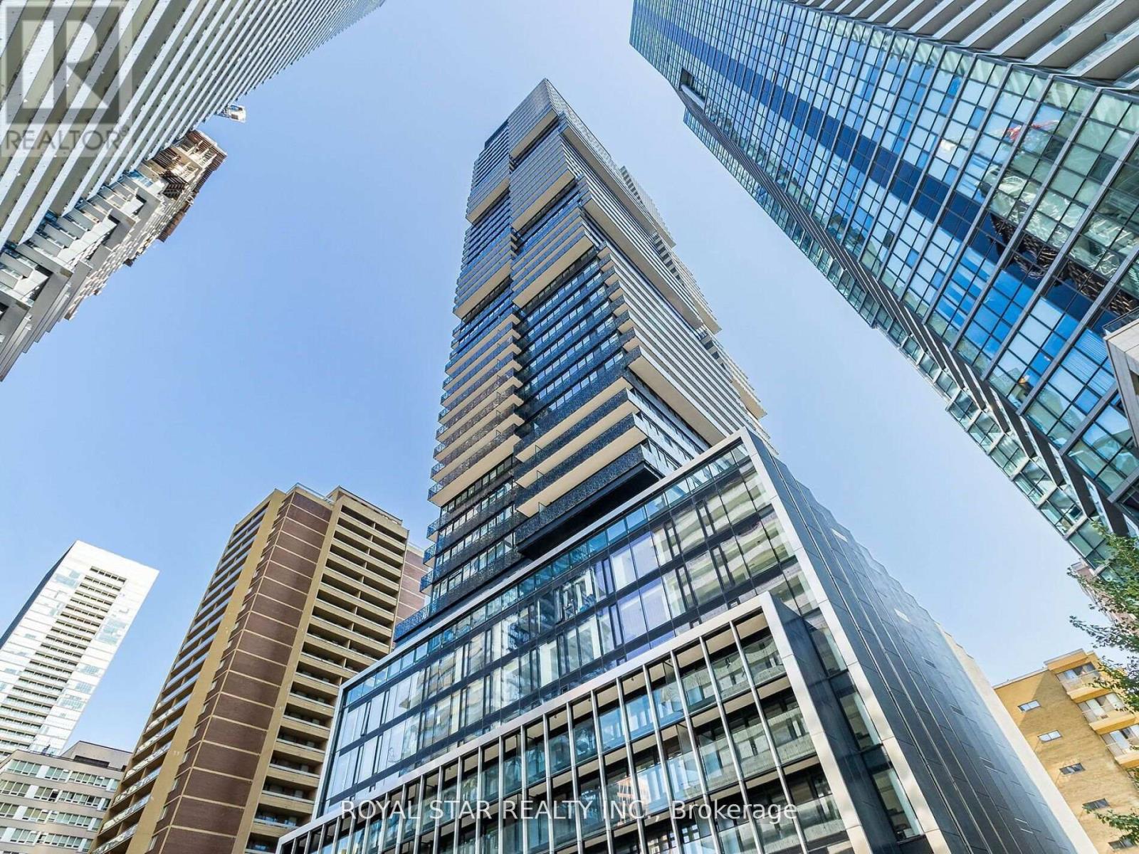 A tall building with a glass facade stands in a cityscape.