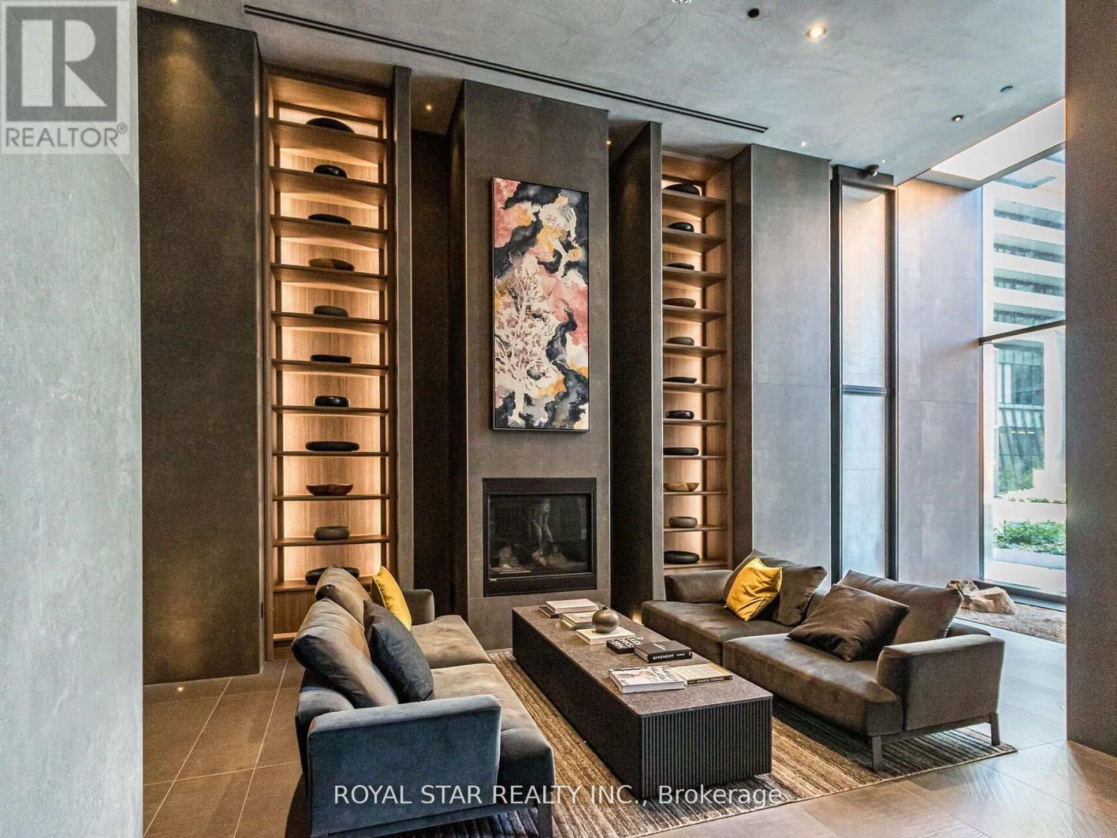 A modern living room with a fireplace and a large painting above it.