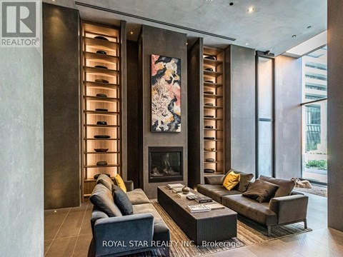 A modern living room with a fireplace and a large painting above it.