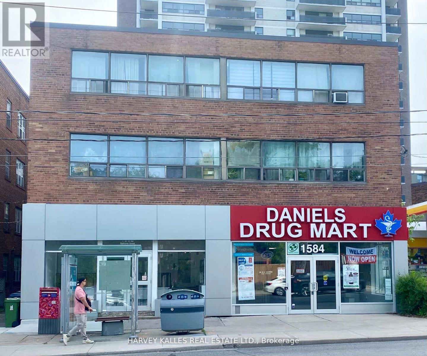 A Daniel's Drug Mart storefront with a man walking by.