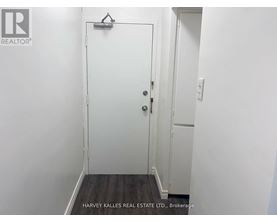 A white door with a black handle is in a white room.