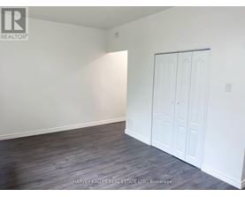 A room with a white door and a grey floor.