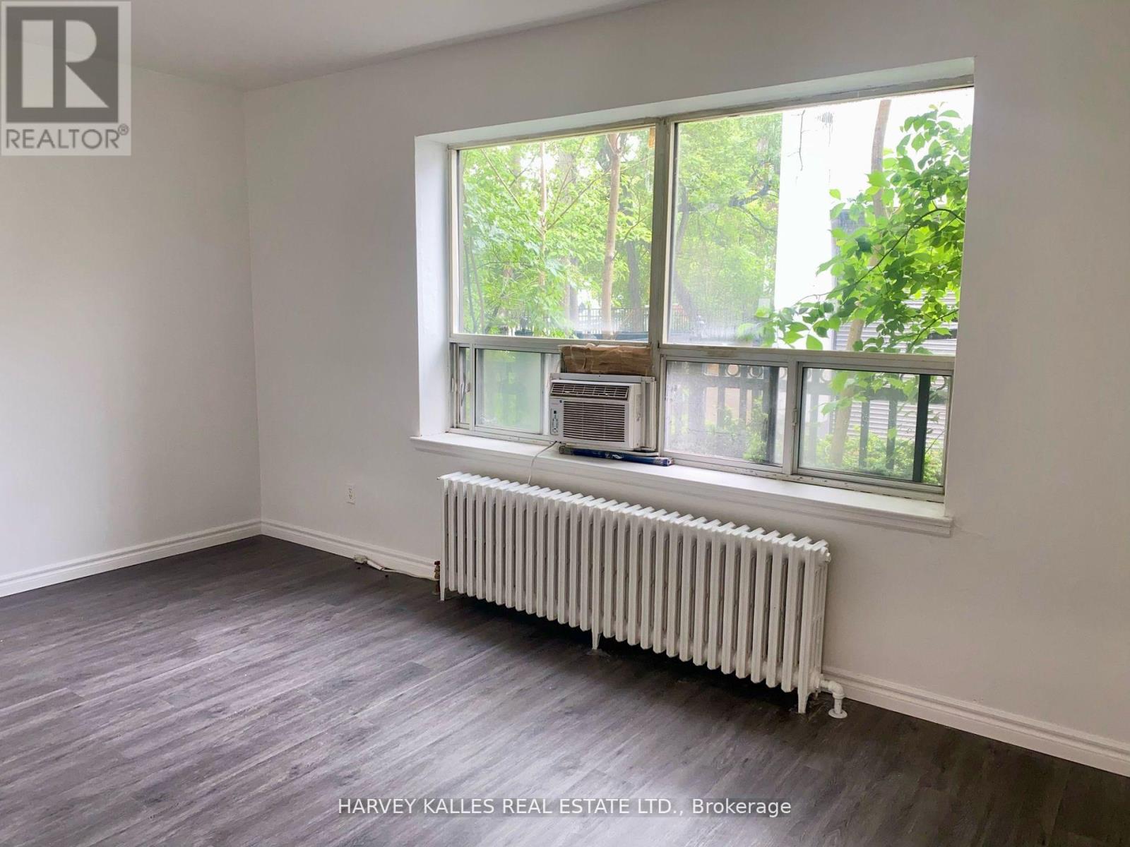 A room with a window and a radiator on the floor.