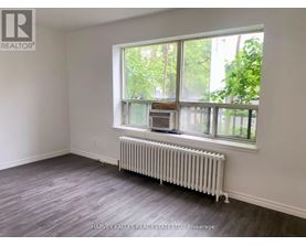 A room with a window and a radiator on the floor.