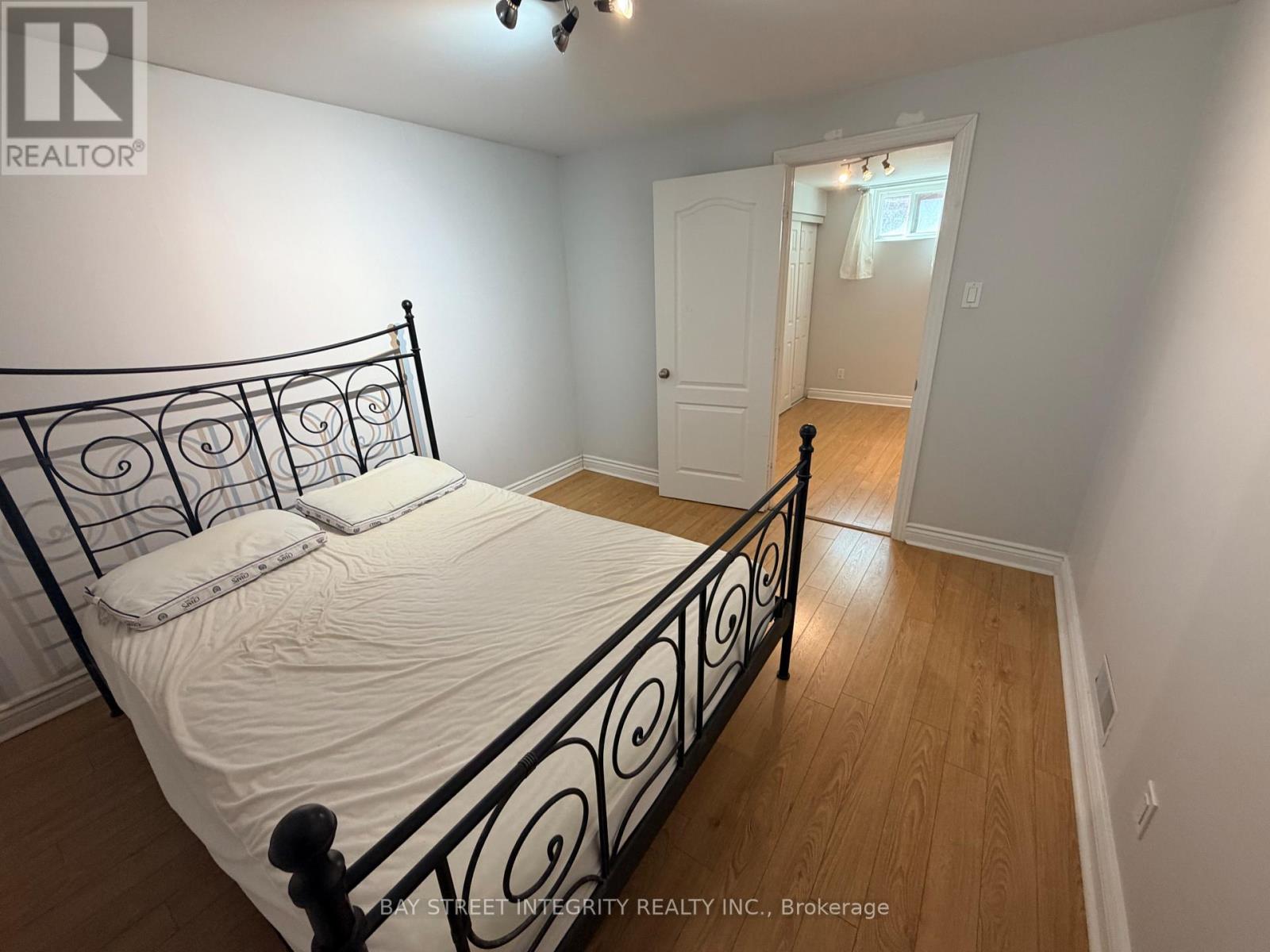 A bedroom with a black metal bed frame and white bedding.