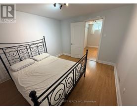 A bedroom with a black metal bed frame and white bedding.