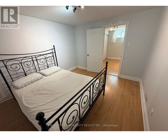 A bedroom with a black metal bed frame and white bedding.