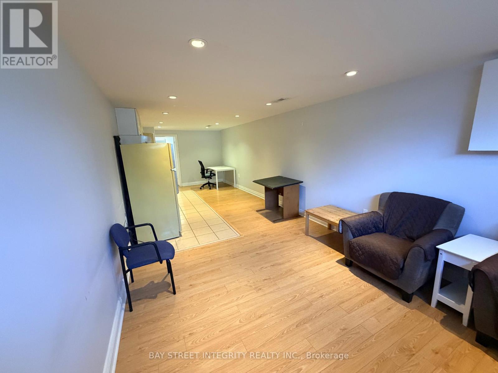 A living room with a blue chair and a brown couch.