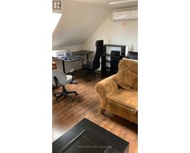 A room with a couch, chairs, and a desk.