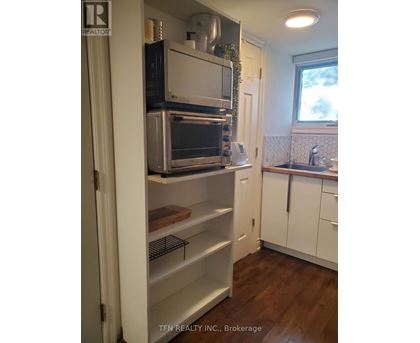 A kitchen with a white fridge and a window.