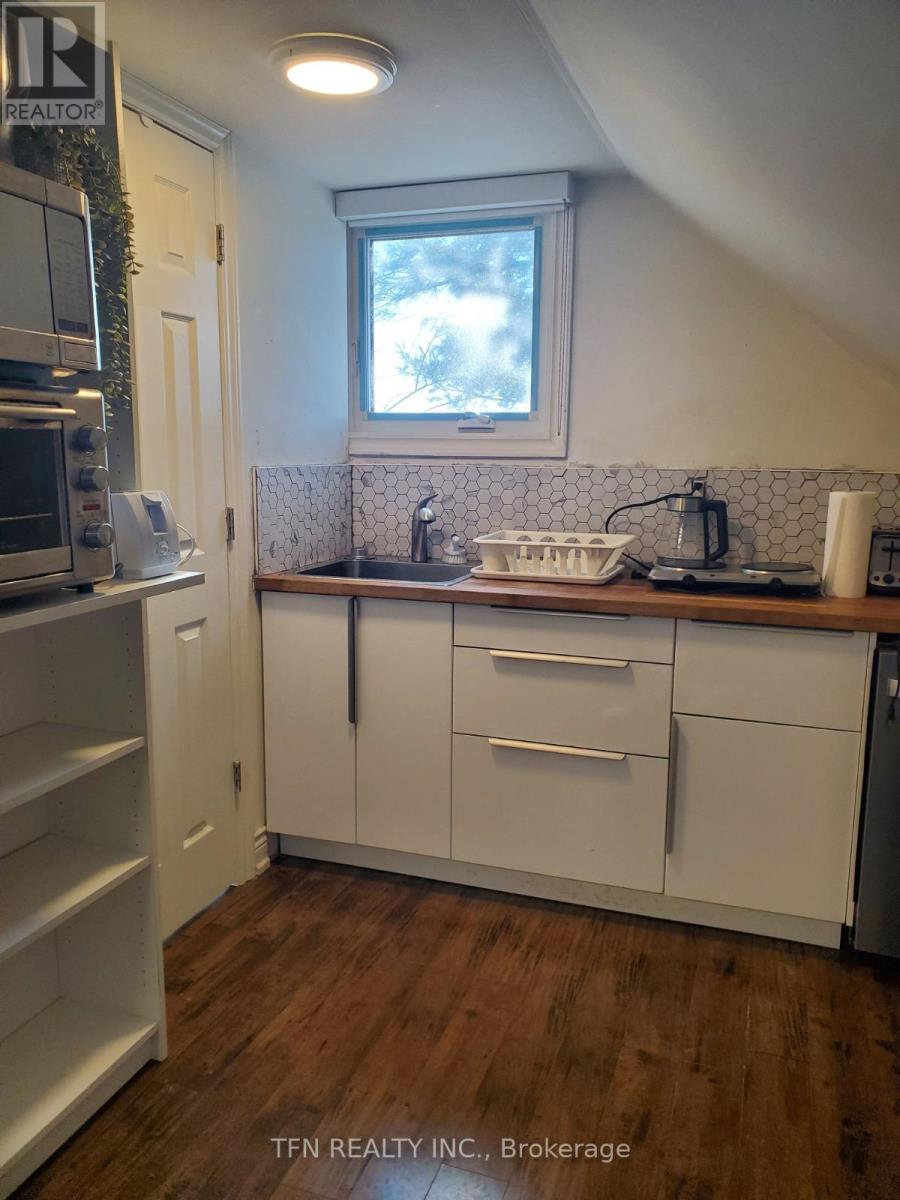 A kitchen with white cabinets and a window above the sink.