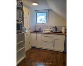 A kitchen with white cabinets and a window above the sink.