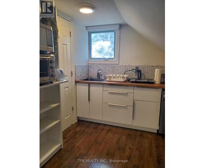 A kitchen with white cabinets and a window above the sink.