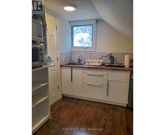 A kitchen with white cabinets and a window above the sink.