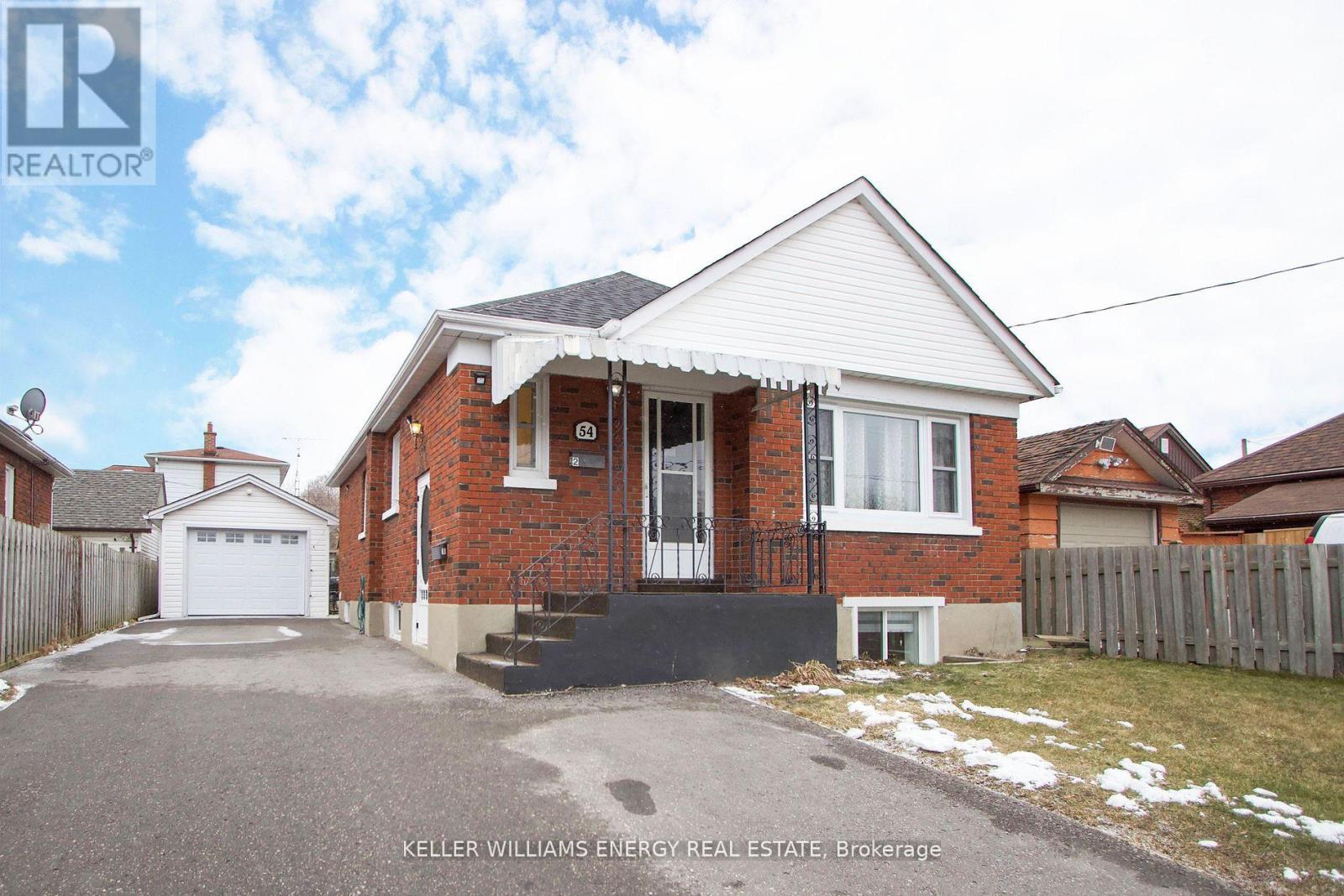 A house with a red brick exterior and a white roof is for sale.