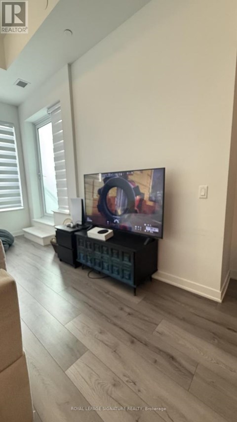 A living room with a television and a remote control on the table.