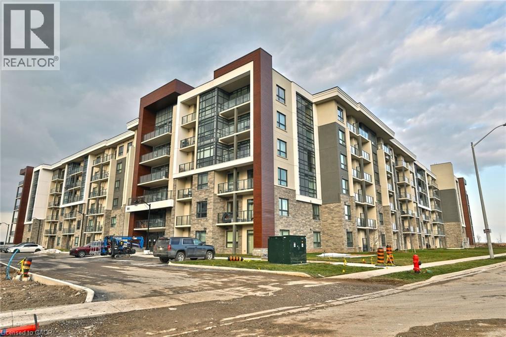 A large apartment building with a parking lot in front.