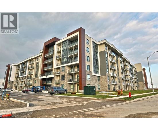 A large apartment building with a parking lot in front.